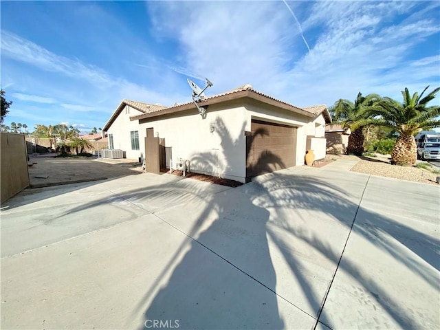 81060 Paloma Cir, Indio, CA 92201 - rear view of house featuring stucco siding, an attached garage, a tiled roof, fence, and concrete driveway