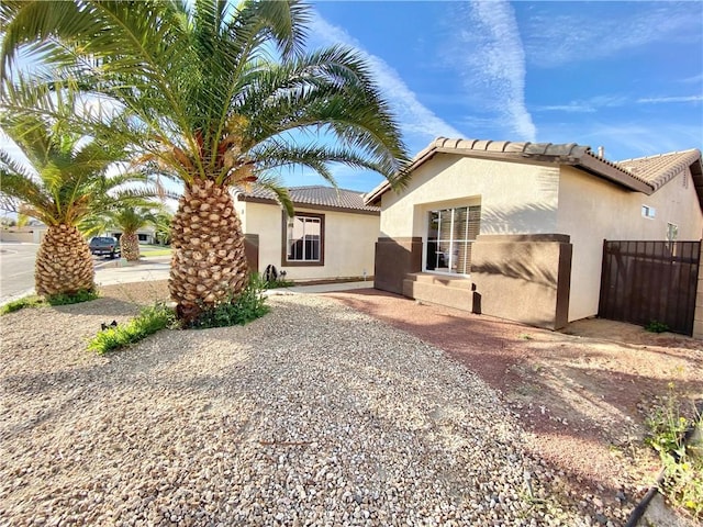 81060 Paloma Cir, Indio, CA 92201 - view of front facade with stucco siding, fence, and a tile roof