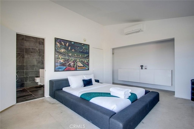 bedroom featuring an AC wall unit and ensuite bathroom