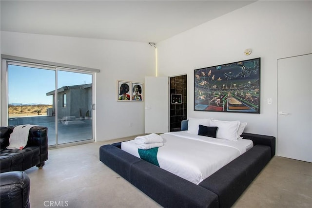 bedroom with access to exterior, high vaulted ceiling, and concrete floors