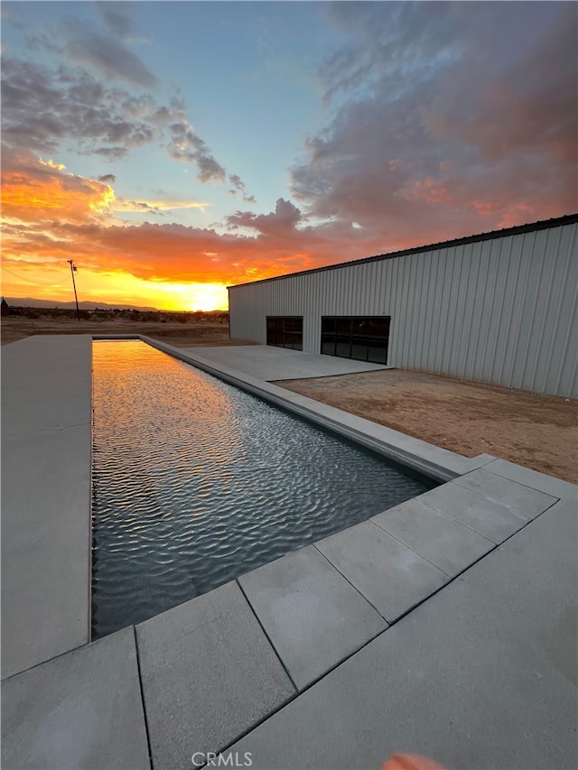 view of pool at dusk