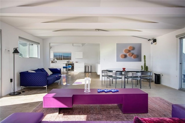 living room with vaulted ceiling with beams and concrete flooring