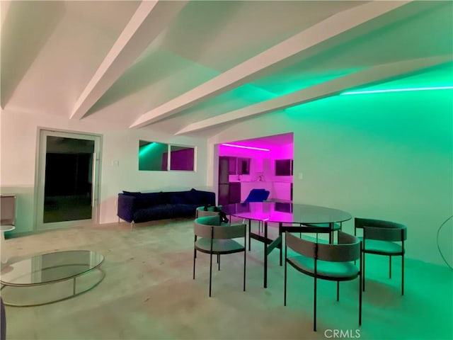 dining room with lofted ceiling with beams and concrete floors