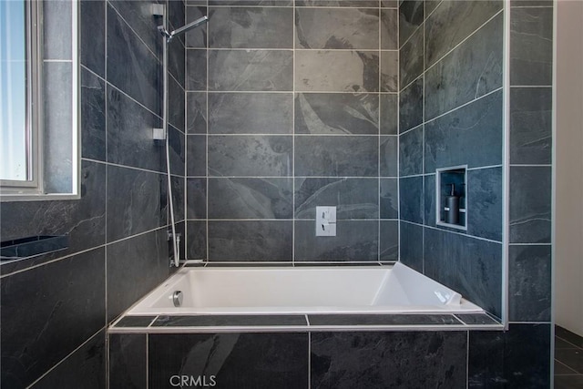 bathroom featuring tiled shower / bath