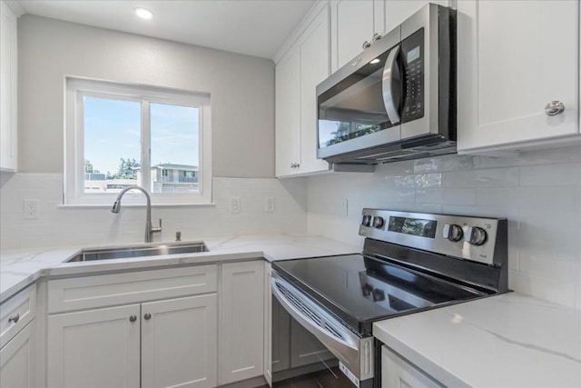 kitchen with white cabinetry, sink, decorative backsplash, and appliances with stainless steel finishes