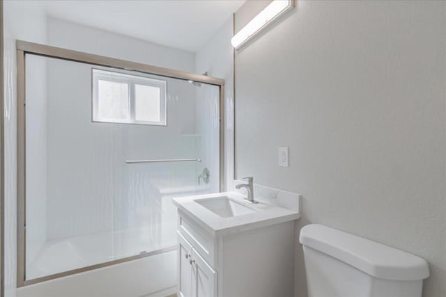 full bathroom featuring enclosed tub / shower combo, vanity, and toilet