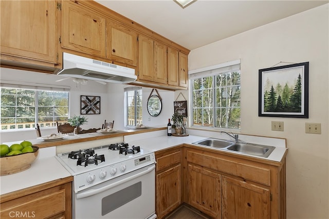 kitchen with white range with gas cooktop, sink, and kitchen peninsula