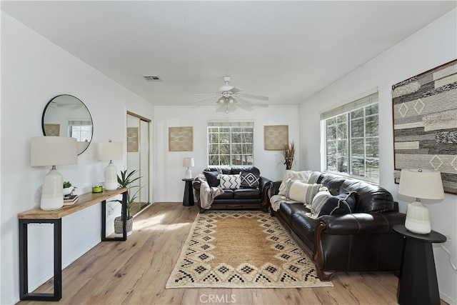 living room with light hardwood / wood-style flooring and ceiling fan