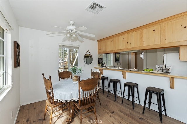 dining space with dark wood-type flooring and ceiling fan