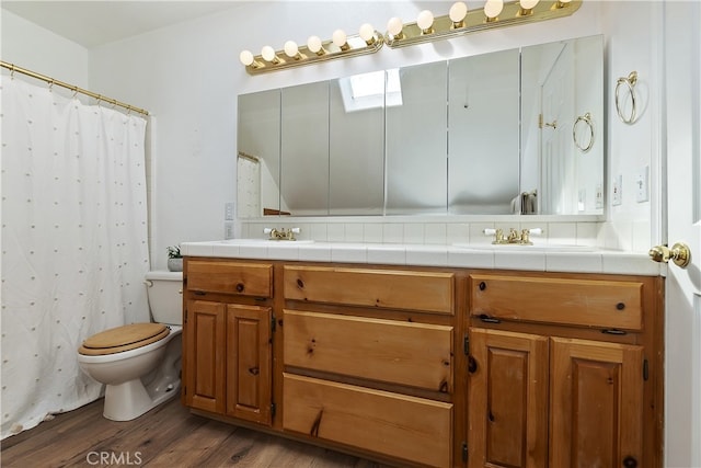 bathroom with toilet, vanity, wood-type flooring, and walk in shower