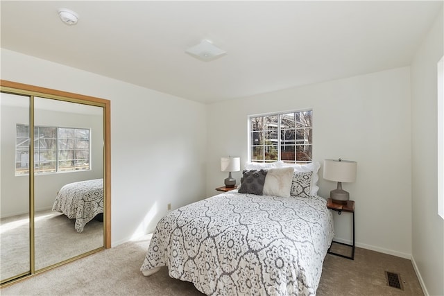 bedroom with a closet and light colored carpet