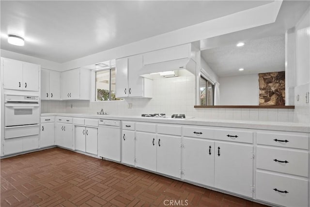 kitchen with white cabinetry, white appliances, and decorative backsplash