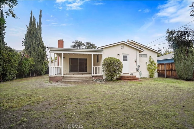 back of property featuring a porch and a lawn