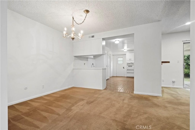 interior space featuring a notable chandelier, a textured ceiling, and carpet flooring