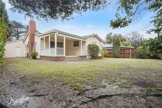 rear view of property with a yard and covered porch