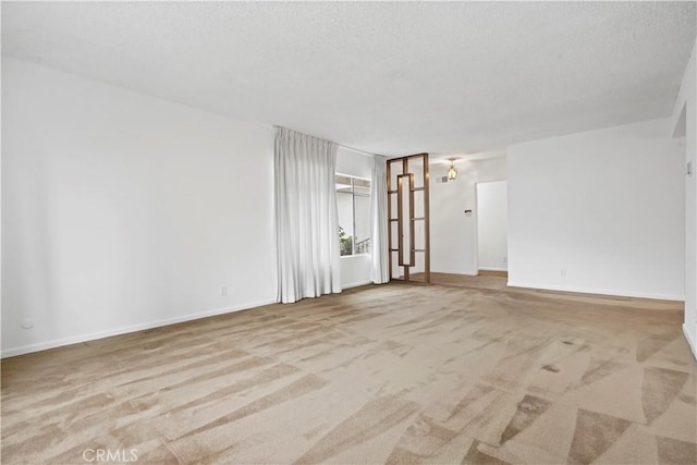 spare room with light carpet and a textured ceiling