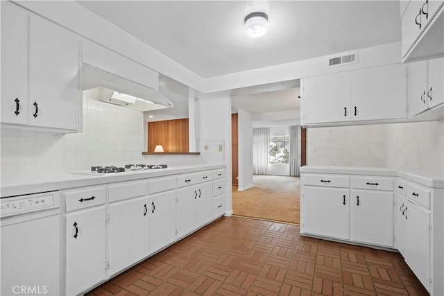 kitchen featuring white cabinetry, white appliances, wall chimney exhaust hood, and decorative backsplash