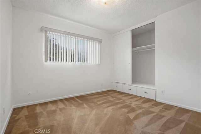 unfurnished bedroom featuring a closet, a textured ceiling, and carpet flooring