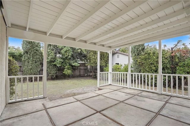 unfurnished sunroom featuring beam ceiling