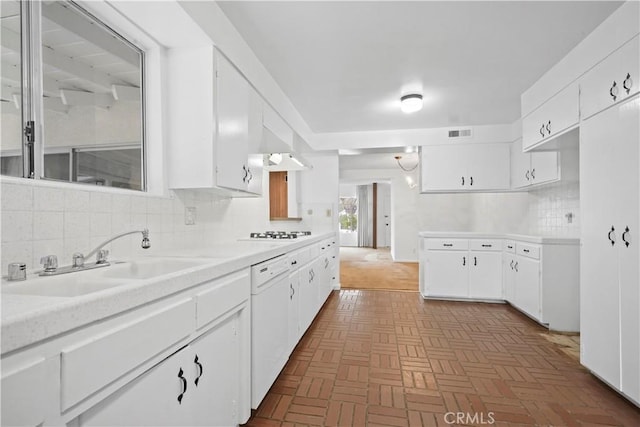 kitchen featuring white cabinetry, sink, backsplash, and white appliances