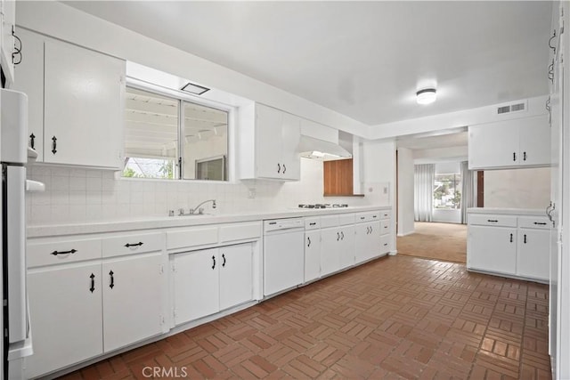 kitchen featuring tasteful backsplash, white cabinetry, sink, custom exhaust hood, and white appliances