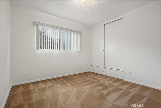 unfurnished bedroom with a closet, a textured ceiling, and carpet flooring