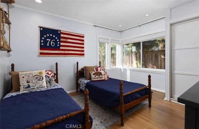 bedroom with hardwood / wood-style flooring and crown molding