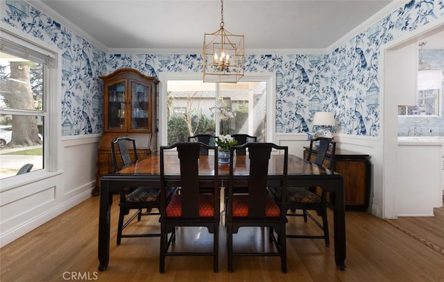 dining room featuring hardwood / wood-style floors, crown molding, and a chandelier