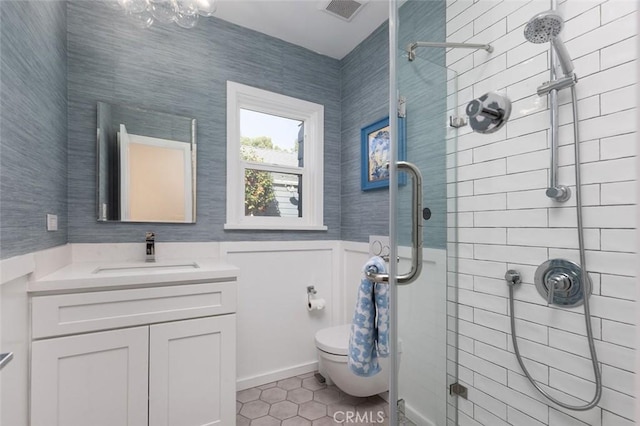 bathroom featuring vanity, a shower with shower door, tile patterned floors, and toilet