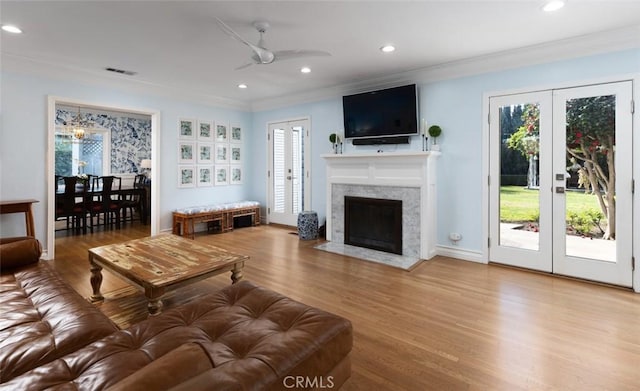 living room featuring hardwood / wood-style floors, crown molding, and french doors