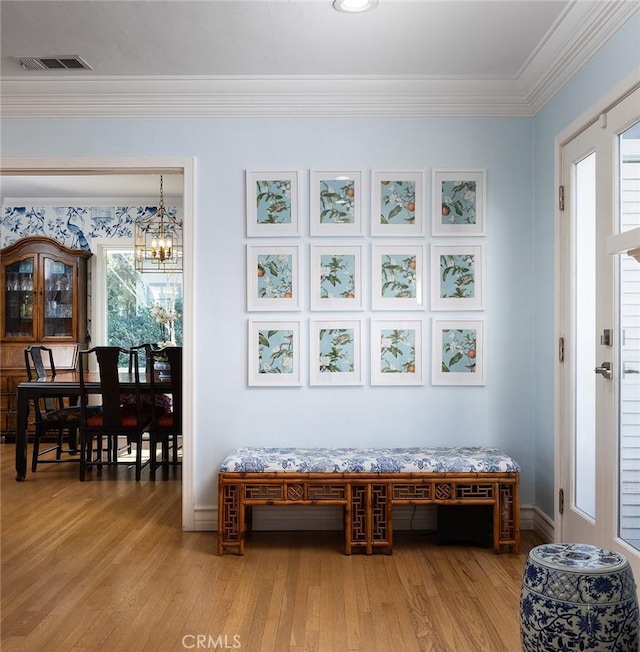 interior space featuring crown molding, hardwood / wood-style floors, and a notable chandelier