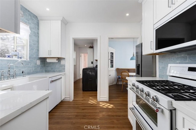 kitchen featuring sink, white appliances, white cabinetry, dark hardwood / wood-style floors, and light stone countertops