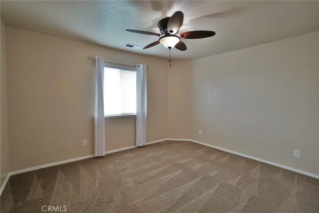 empty room featuring ceiling fan and carpet