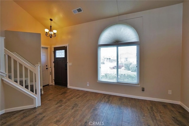 entryway with dark wood-type flooring, vaulted ceiling, and a notable chandelier