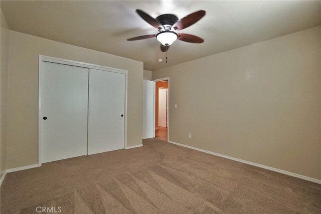 unfurnished bedroom with carpet, ceiling fan, and a closet