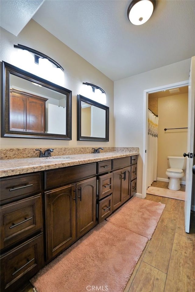 bathroom featuring vanity, hardwood / wood-style floors, and toilet