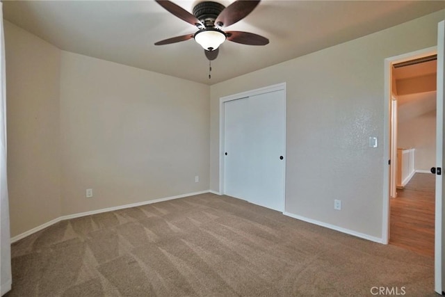 unfurnished bedroom featuring light carpet, a closet, and ceiling fan