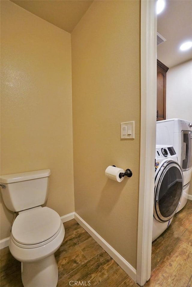 bathroom with washer / clothes dryer, hardwood / wood-style floors, and toilet