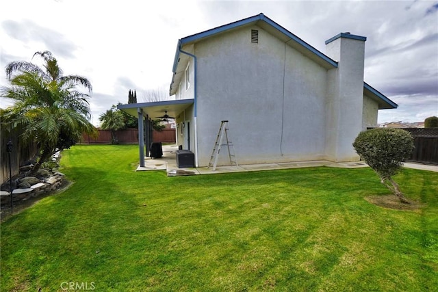 back of property featuring a yard, ceiling fan, and a patio area