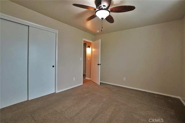 unfurnished bedroom featuring carpet floors, ceiling fan, and a closet