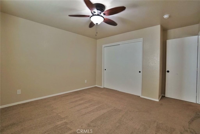 unfurnished bedroom with carpet, ceiling fan, and a closet