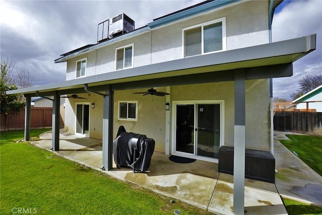 rear view of property with a yard, ceiling fan, and a patio area