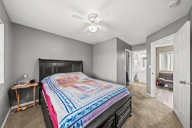 carpeted bedroom with ceiling fan, connected bathroom, and baseboards