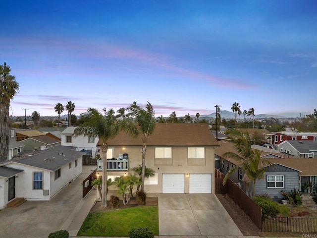 view of front of property with a garage, fence, driveway, a residential view, and stucco siding