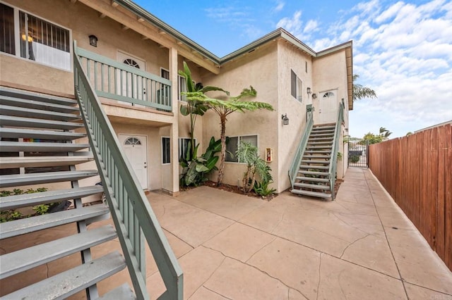 view of property featuring fence and stairway