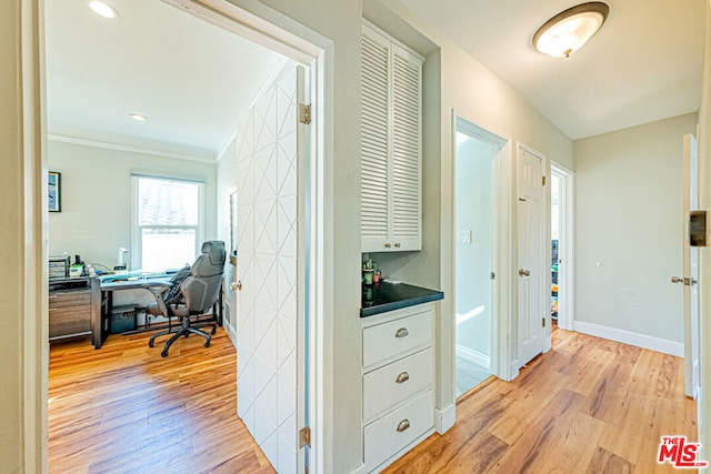 hallway featuring crown molding and light wood-type flooring