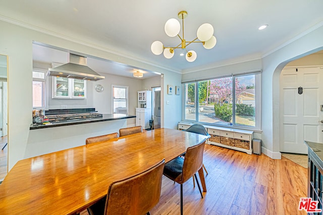 dining area with crown molding, a wealth of natural light, and light hardwood / wood-style floors