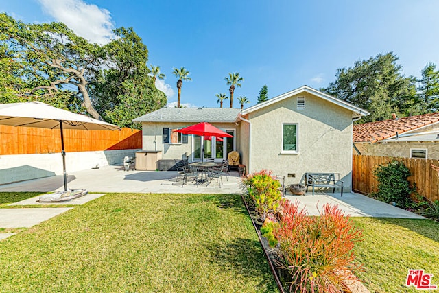 rear view of house with a yard and a patio area