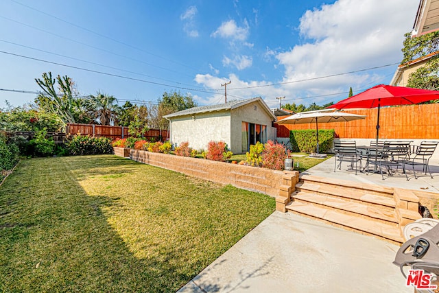 view of yard with a patio and an outbuilding