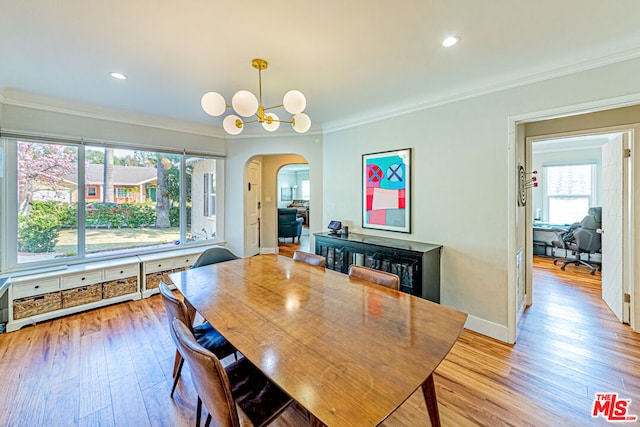 dining room with an inviting chandelier, crown molding, and light hardwood / wood-style floors